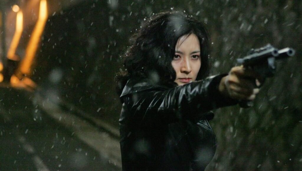 To Fight Against Historical Amnesia: Park Chan-wook’s Lady Vengeance Lady Vengeance: Woman aims gun in the rain. Crime, action movie scene.