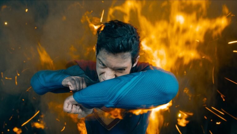 David Corenswet as Superman in James Gunn's Superman movie. Fire and sparks surround him.