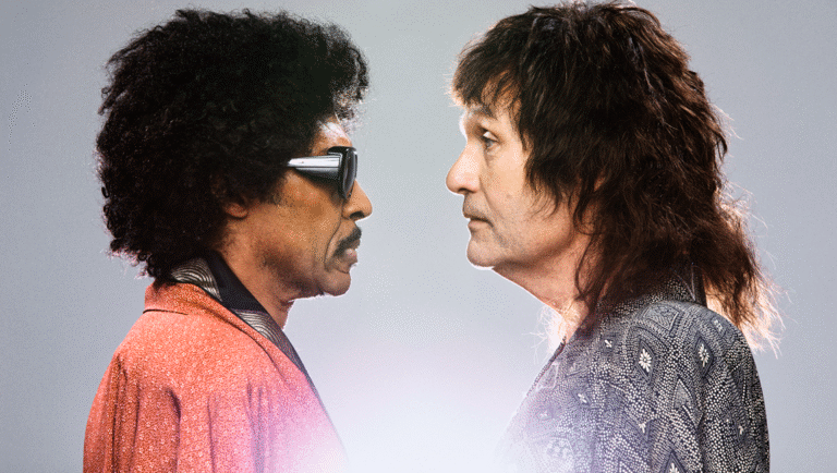 Sparks brothers Ron and Russell Mael face to face. Ron has an afro and sunglasses. Russell has long hair. Musical duo.