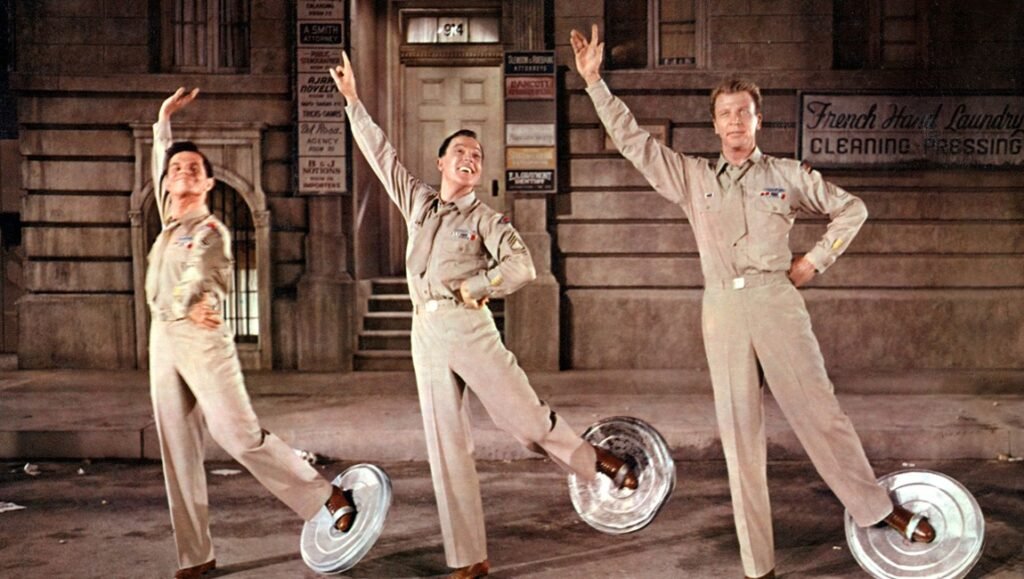 The Psychotic Break of the American Mid-Century: Donen & Kelly’s It’s Always Fair Weather Fair Weather movie still. Three men in military uniforms dance with metal plates on their feet. Musical film scene.