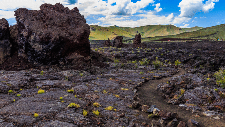 It’s After the End of the World!: On Peter Fonda’s Idaho Transfer, Lovecraft, and the Present Apocalypse Idaho's Craters of the Moon: Black lava field, trail, mountains, and blue sky with clouds. Volcanic landscape.