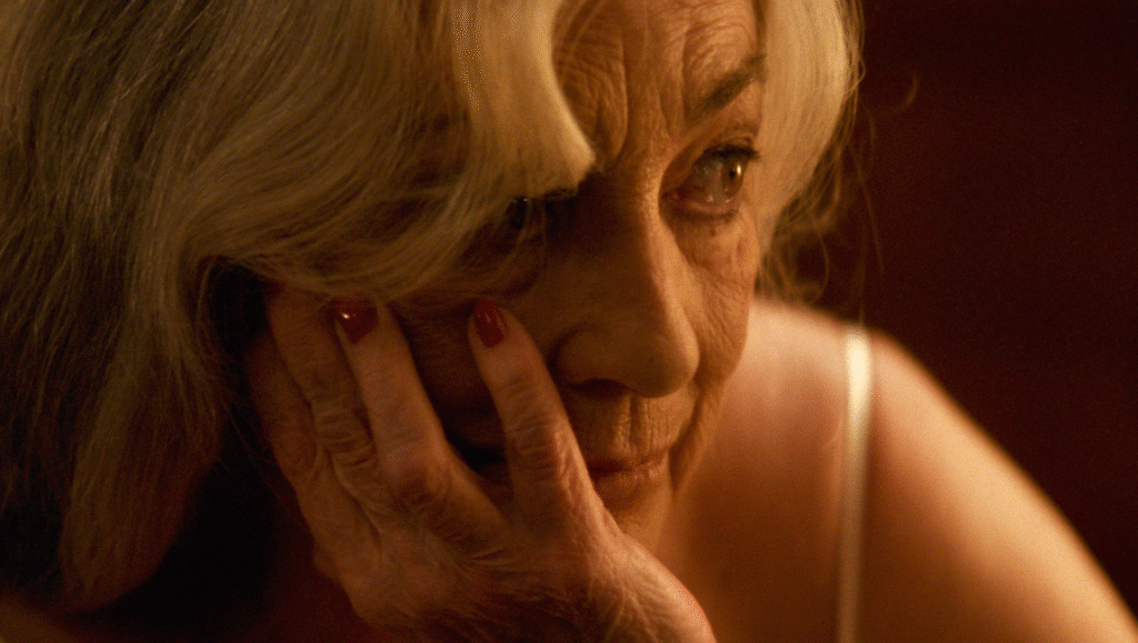 Still from Calle Málaga: Close-up of an older woman's face, hand resting on her cheek. TIFF '25 review.
