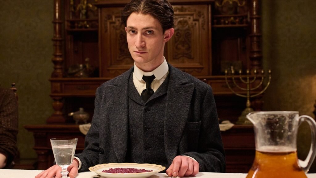 Still from Franz at TIFF 2025. Man in suit at dinner table. Period drama.