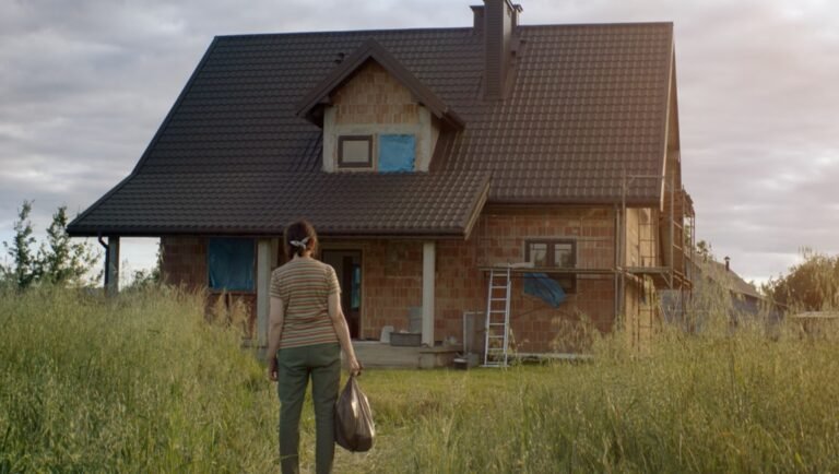Woman walking towards a new house construction. Homeownership dream, real estate.