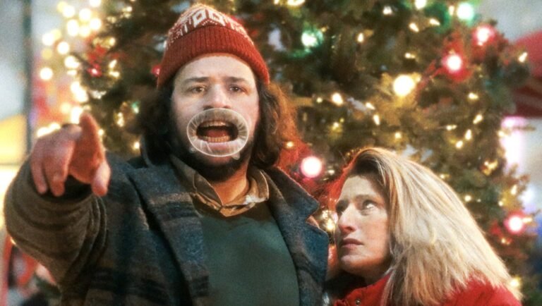 The Baltimorons still: Jay Duplass points, Liz Larsen looks concerned near a Christmas tree. Comedy film.