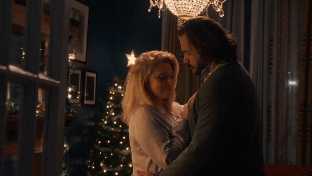 Liz Larsen and Jay Duplass in The Baltimorons, a Christmas movie. Couple embraces near a decorated Christmas tree.