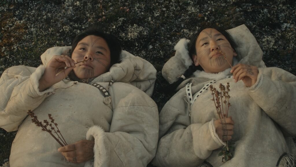 Wrong Husband still: Two Inuit women in traditional clothing lying on the ground.