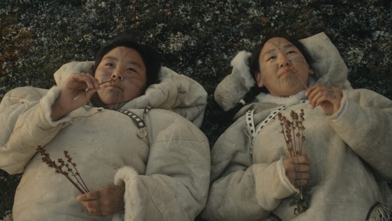 Wrong Husband still: Two Inuit women in traditional clothing lying on the ground.