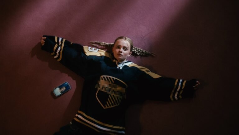 Girl in hockey jersey lying on floor. Teen with braids, vintage photo.