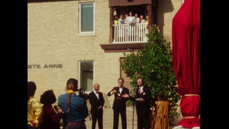 Still from Levers at NYFF. People on a balcony and below, with a red-draped object.