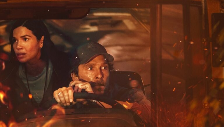 The Lost Bus review: Paul Greengrass film scene with terrified bus driver and passenger amid flames.