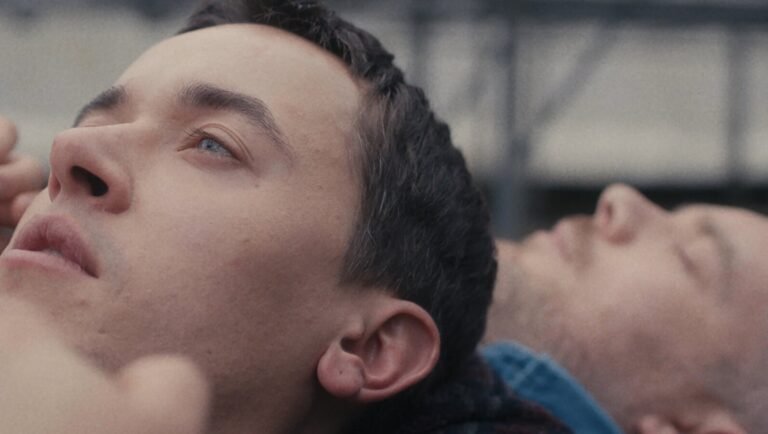 Review of Yeon Sang-ho's The Ugly: Close-up of two men lying down, one with striking blue eyes. Plainclothes.