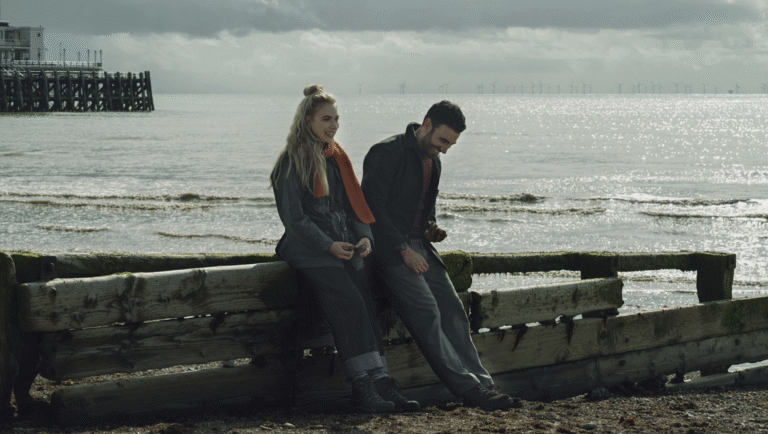 All of You movie review image: Couple sits on a beach. William Bridges film.