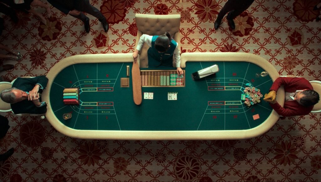 London Film Festival 2025 — Dispatch 1: Ballad of a Small Player, The Souffleur, Promised Sky Overhead shot of a baccarat table with players and a dealer in a casino. Gambling.
