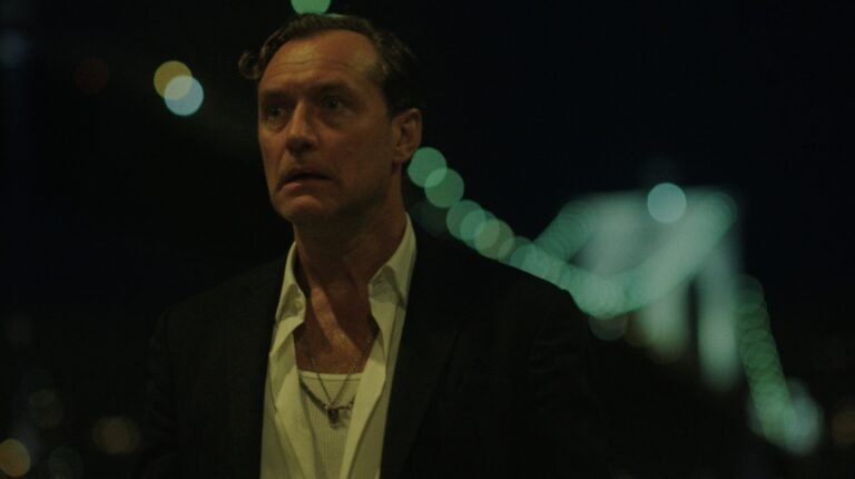 Black Rabbit S1 E7: Man in suit with necklace at night. Crime drama scene.