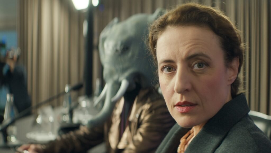 Gavagai NYFF '25 film review: Woman and person in elephant mask. Ulrich Köhler film still.