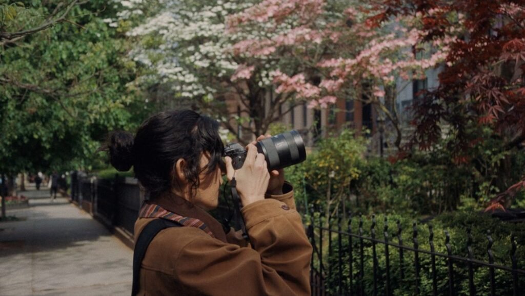 Mimi Davila as Sofia in The Scout. Woman with camera in park, capturing nature. Paula González-Nasser directs.