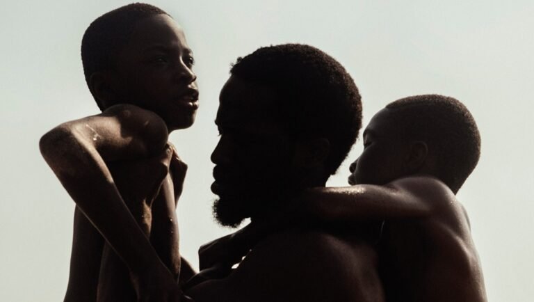 Silhouette of African father with two sons. Family love and togetherness concept.