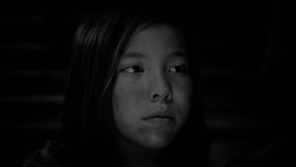 Black and white still from Ben Rivers' film Mare's Nest, featuring a young woman.