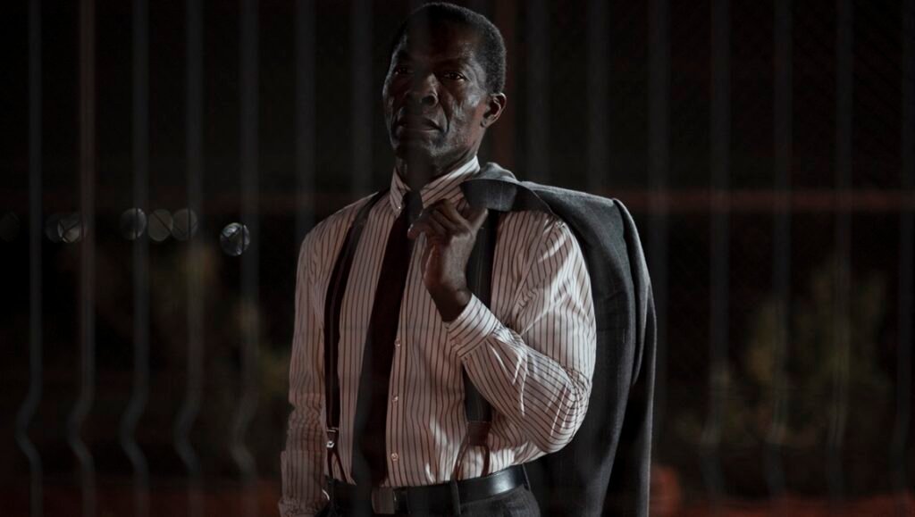 London Film Festival: Scene from The Fence film. Man in shirt, tie, and suspenders with a jacket over his shoulder.