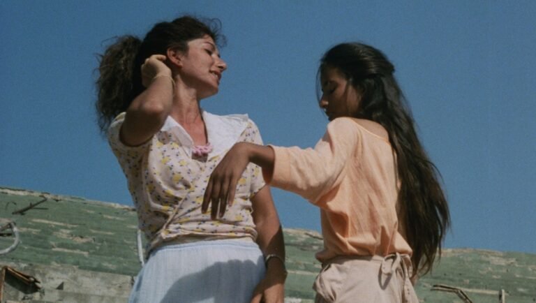 Ghazl El-Banat film still. Two young women in vintage attire against a blue sky. NYFF '25 Review.
