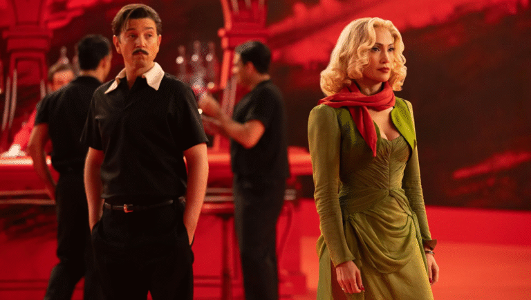 Scene from Kiss of the Spider Woman with actors in costume. Man in black, woman in green dress.