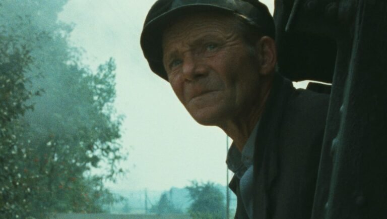 Genocide Revisited: Shoah at 40 Still from Shoah, a documentary film about the Holocaust. A man in a cap looks out from a train. Genocide revisited.