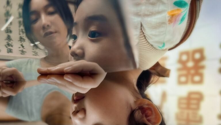 Shih-Ching Tsou's Left-Handed Girl review image: Girl's reflection with woman in background.