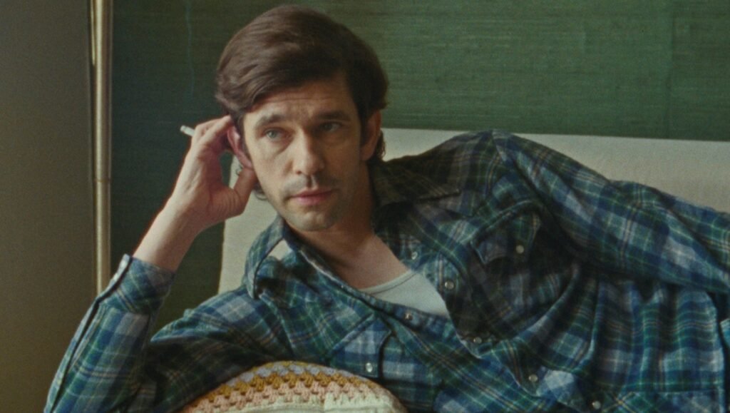 Still from Peter Hujar's Day. Ben Whishaw in a plaid shirt, smoking. Indie film.