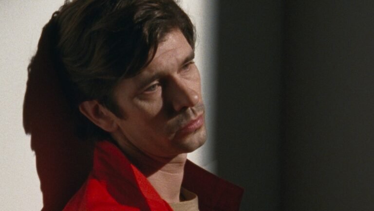 Peter Hujar's Day: Still Portrait. Man in red jacket, contemplative expression. Film still.