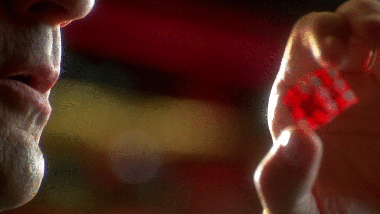 Robert De Niro in Casino (1995) holding a red dice, gambling scene, film still, casino games, luck, chance, winning, losing.