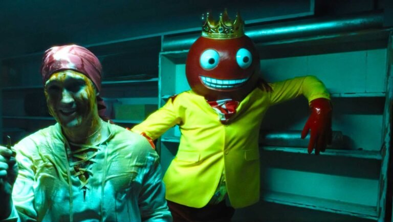 Anniversary movie scene: man covered in goo, and a person in a cartoonish king costume.