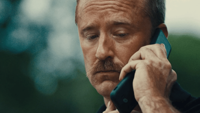 King Ivory movie review: Man with mustache talking on cell phone, looking concerned.