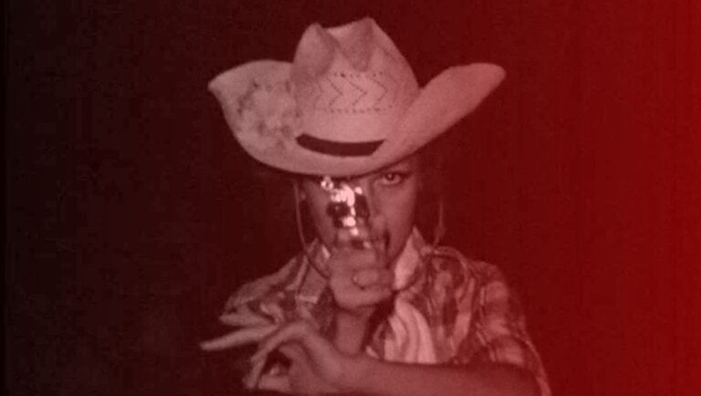 Under the Flags, the Sun film still: Person in cowboy hat and patterned shirt, Juanjo Pereira review image, Icarus Films.