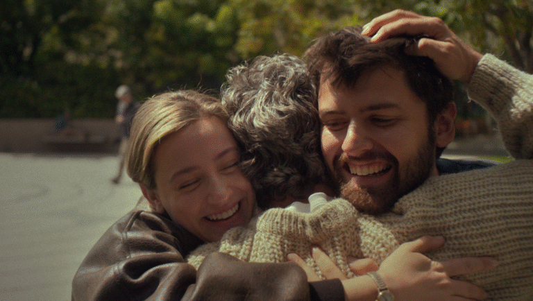Hal & Harper movie review: Smiling cast embrace in outdoor scene. Cooper Raiff film. Warm, emotional connection.