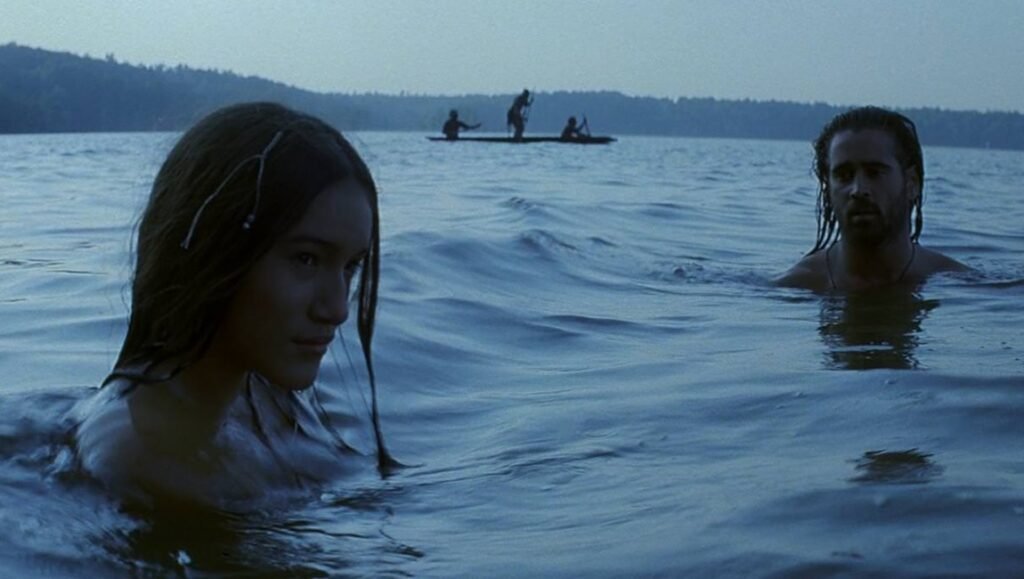 The New World movie scene: Pocahontas (Q'orianka Kilcher) and John Smith (Colin Farrell) in water with native canoe in the background.