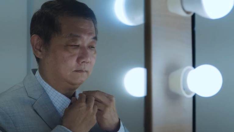 Singapore International Film Festival — Dispatch 2: The Old Man and His Car, Sandbox, Coda Singapore Film Festival: Man adjusts tie in mirror, possibly from 'The Old Man and His Car' film screening.