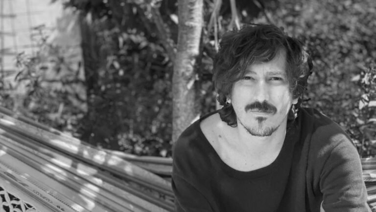 Simon Mesa Soto black and white portrait: Interview with the artist, showcasing his distinctive look and artistic persona.