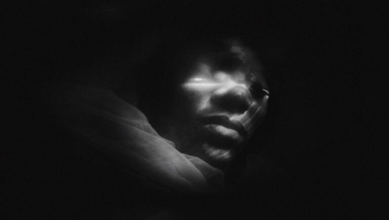 IFFR 2026 First Days: Abstract black and white image of a face with bright light on the eyes, dark and mysterious.