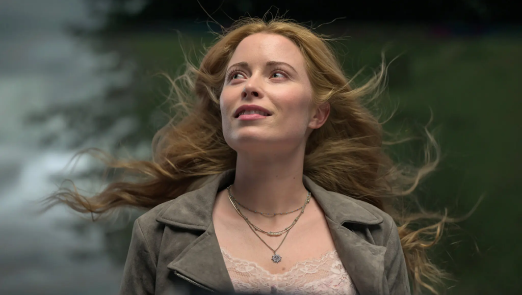 Return to Silent Hill movie still: A blonde woman looking up hopefully in a scene from the film.