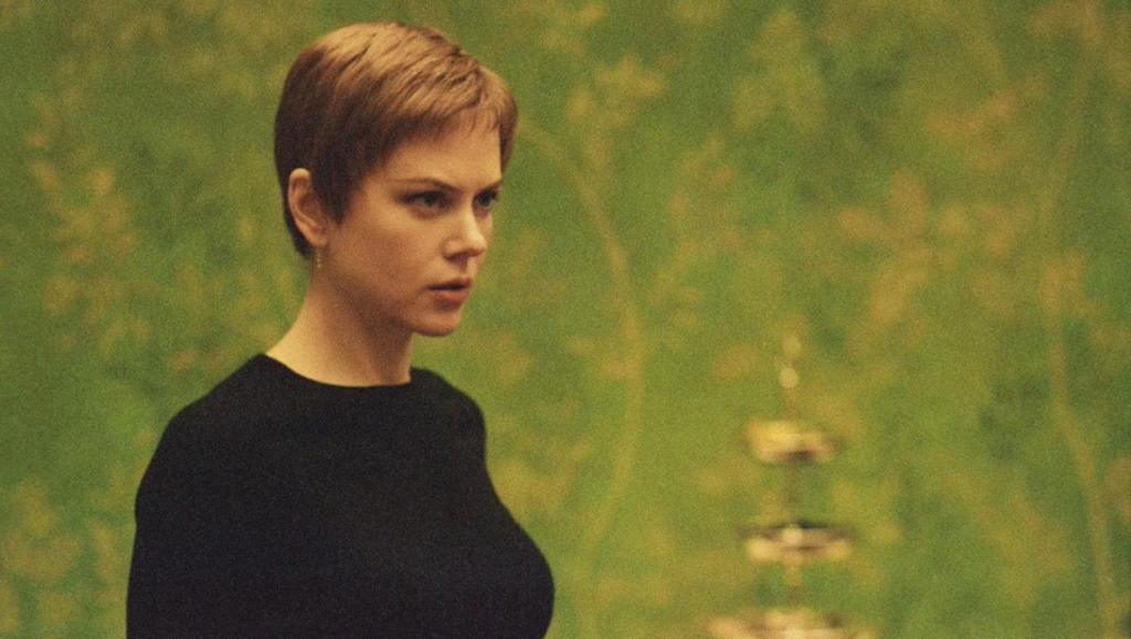 Nicole Kidman stares intensely in Jonathan Glazer's film Birth, set against a green backdrop.