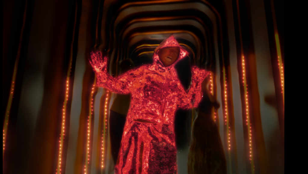 2026 LAFM Shorts Program still: Red-clad figure in a hooded robe with arms raised in a tunnel setting, glowing lights