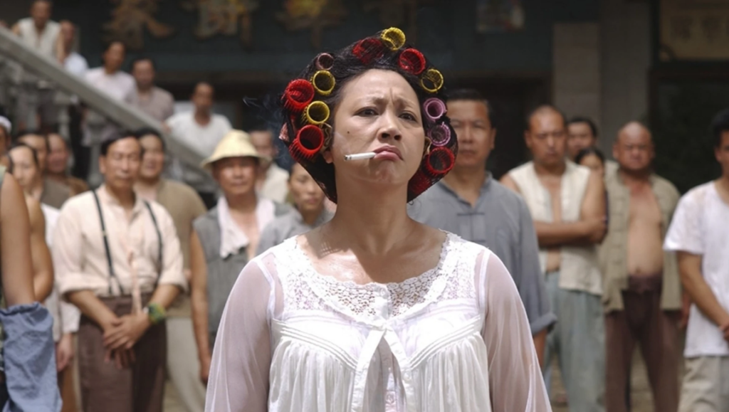 Kung Fu Hustle image: Landlady with curlers and cigarette, a comedic scene from Stephen Chow's parody martial arts film.