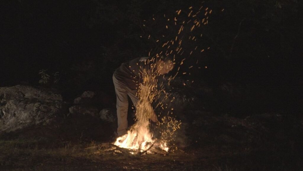 Karthik Pandian, USA, 2025, tending a bright campfire at night, sparks flying at the 2026 Images Festival.
