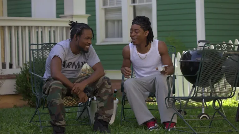 RZA 'One Spoon of Chocolate' review: Two men sit outdoors by a grill, enjoying a sunny day and good conversation.
