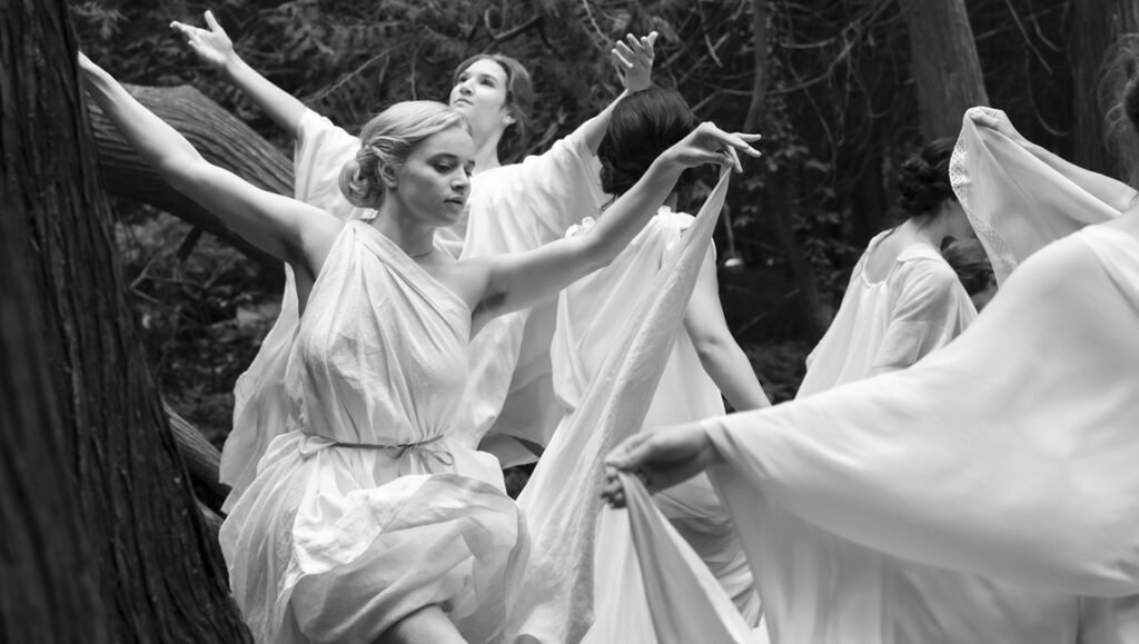 Luna Wedler in Silent Friend; black and white image of women in flowing white dresses in a forest, artistic film scene.