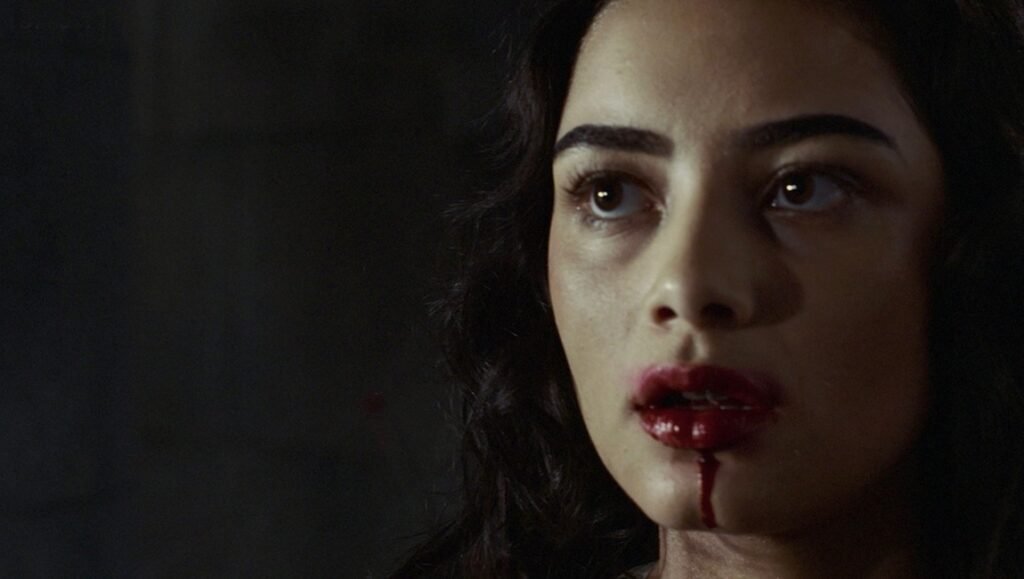 Fantasia Fest 2026 — Dispatch 1: Our Effed Up World, The Samurai and the Prisoner, Dance Freak Close-up of a dark-haired woman with bright red blood staining her lips and chin against a dark background.