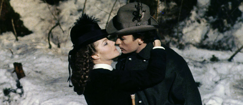 The Hollow Magnitude of Luchino Visconti’s Ludwig A man and woman in 19th-century winter attire embrace closely in a snowy landscape.