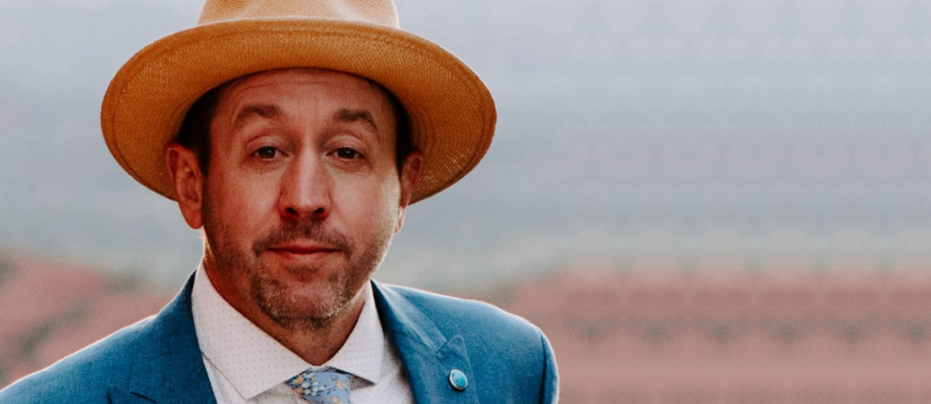 Going Home Exhausted and Beat Up: An Interview with Potsy Ponciroli on Motor City Potsy Ponciroli wearing a tan fedora, blue blazer, and patterned tie looking directly at the camera.