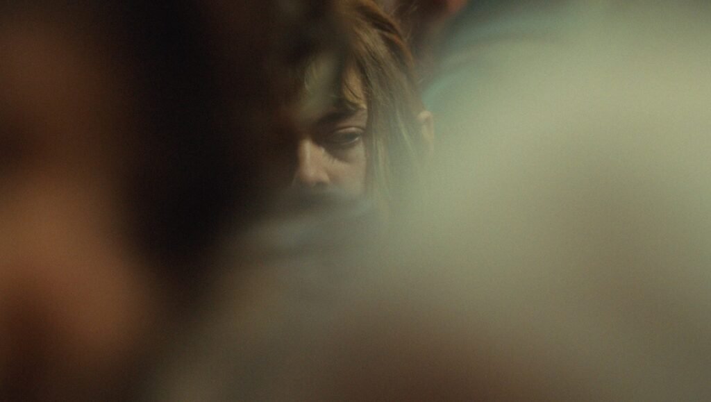 Close-up of a person with tired eyes partially obscured by a soft, glowing haze.
